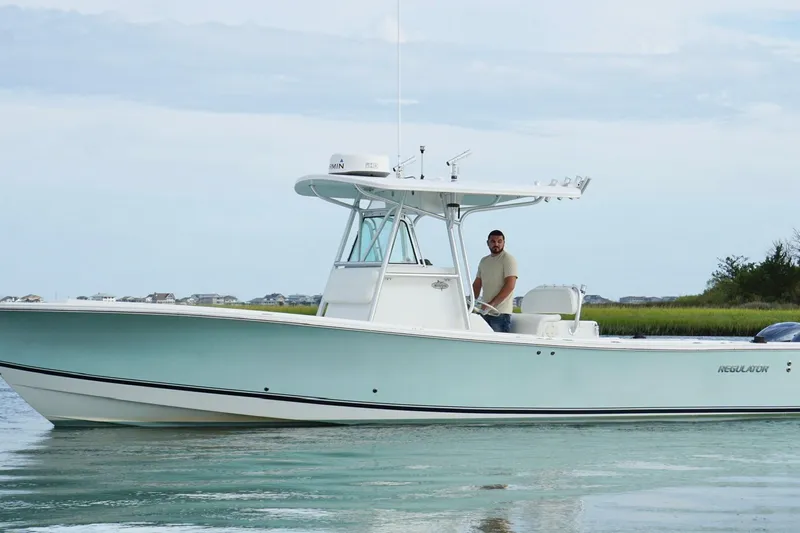  Yacht Photos Pics 2006 Regulator 32 Forward Seating boat on calm water with a person at the helm.