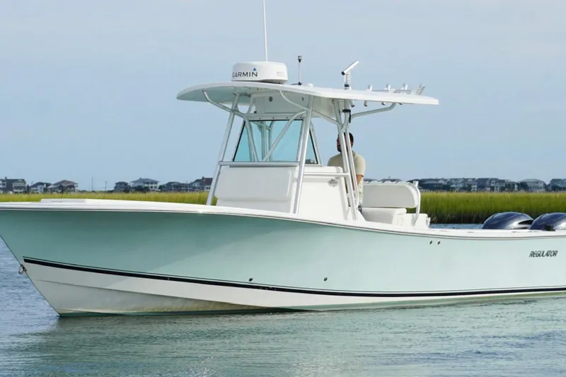  Yacht Photos Pics 2006 Regulator 32 Forward Seating boat on calm water, coastal background.