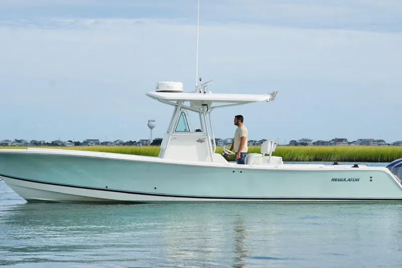  Yacht Photos Pics 2006 Regulator 32 Forward Seating boat on calm water, with a person standing at the helm.