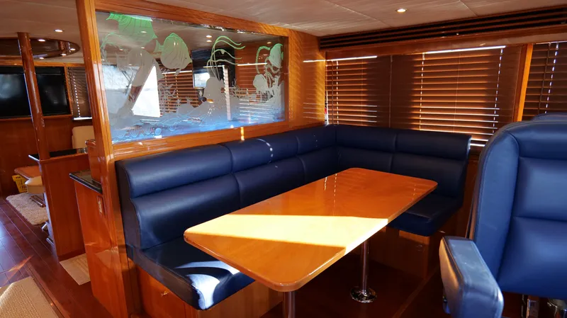  Yacht Photos Pics Luxurious 2007 Jefferson Marquessa yacht interior with blue seating and wooden table.