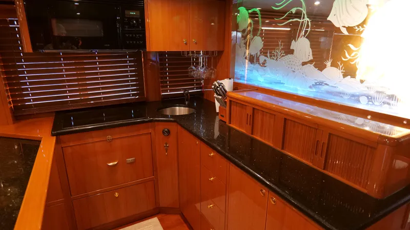  Yacht Photos Pics Luxurious kitchen interior of 2007 Jefferson Marquessa yacht with wood cabinetry and aquarium.