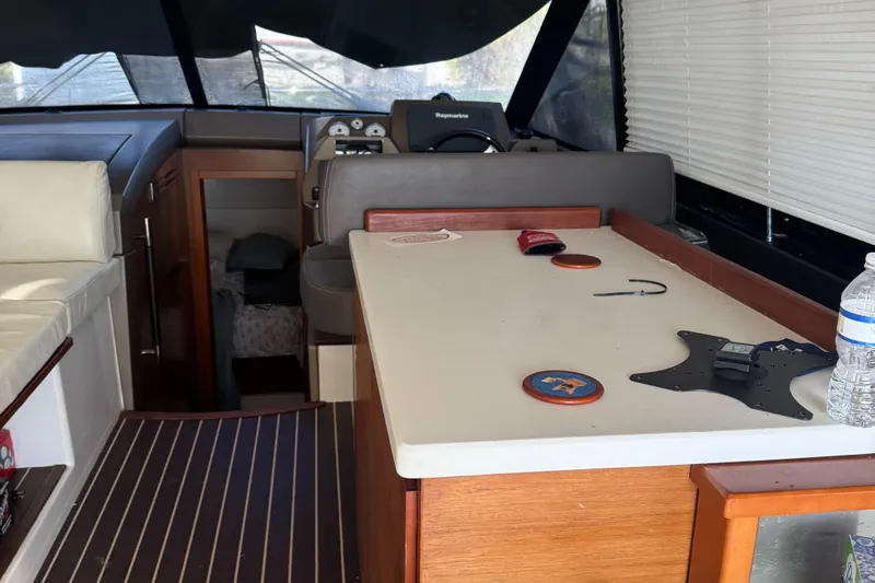  Yacht Photos Pics Interior of a 2015 Prestige 450 yacht with helm, table, and seating area.