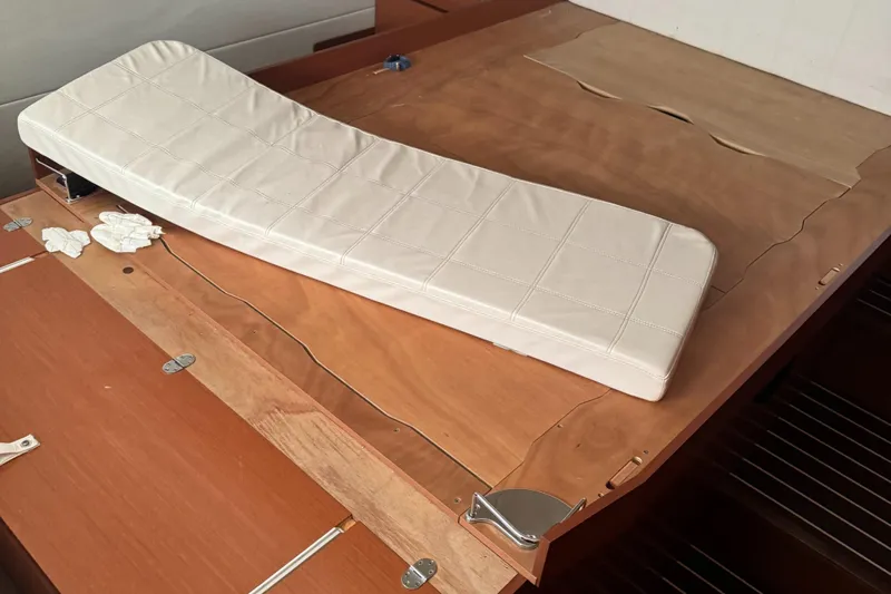  Yacht Photos Pics Interior of a 2015 Prestige 450 yacht with wooden surfaces and a white cushion.