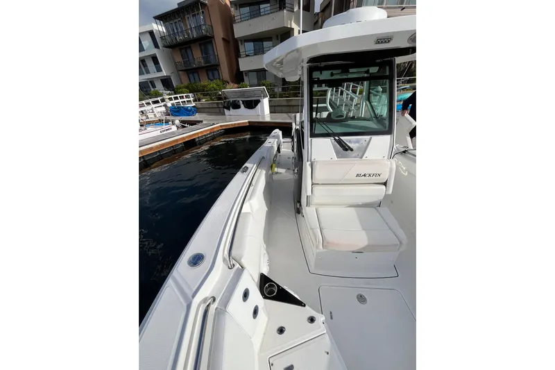  Yacht Photos Pics 2019 Blackfin 272 CC boat docked near modern buildings.