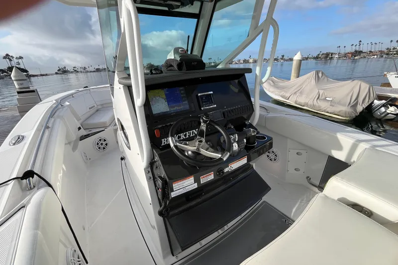  Yacht Photos Pics 2019 Blackfin 272 CC boat interior with helm, docked by calm waters.