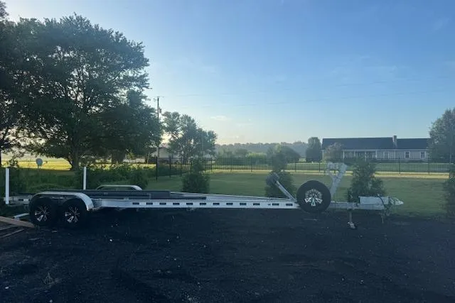  Yacht Photos Pics 2023 Scout 277 LXF trailer parked on a rural property with trees and a house.