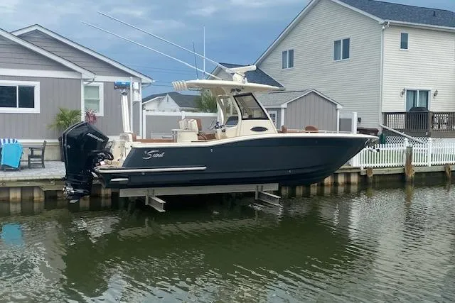  Yacht Photos Pics 2023 Scout 277 LXF boat docked by waterfront homes.