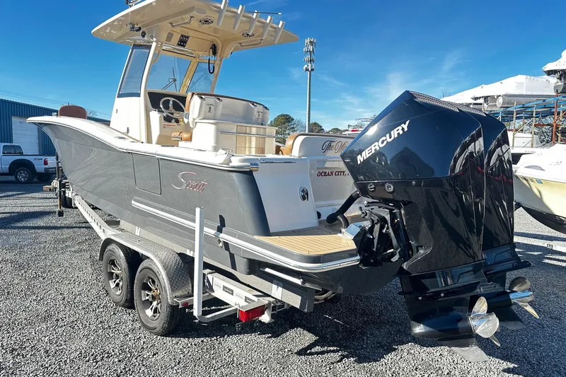  Yacht Photos Pics 2023 Scout 277 LXF boat with Mercury engine on trailer, parked outdoors.