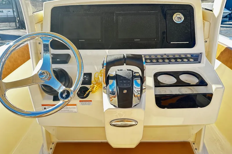  Yacht Photos Pics 2023 Scout 277 LXF boat dashboard with steering wheel and control panel.