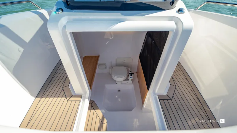  Yacht Photos Pics 2025 Rand Roamer boat interior with modern bathroom and wooden flooring.