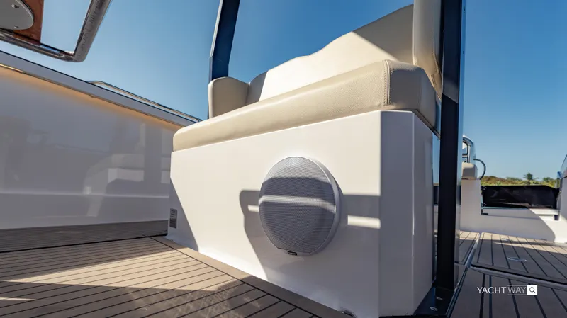  Yacht Photos Pics 2025 Rand Roamer boat interior with cushioned seating and speaker on deck.