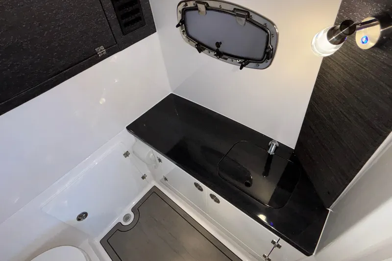 Yacht Photos Pics Modern bathroom interior of 2026 Monterey Elite 30 OB boat, featuring sleek black countertop.