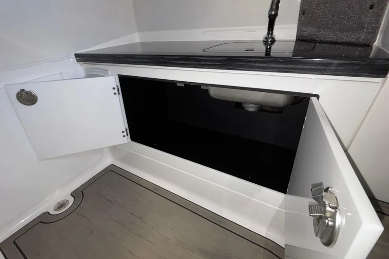  Yacht Photos Pics 2026 Monterey Elite 30 OB boat interior with open storage compartment and sleek countertop.