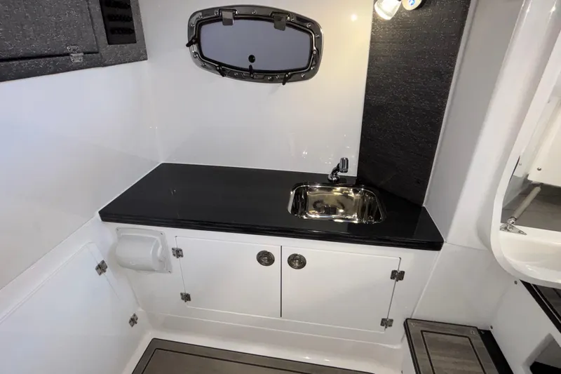  Yacht Photos Pics Interior of 2026 Monterey Elite 30 OB boat featuring a compact sink and storage cabinets.