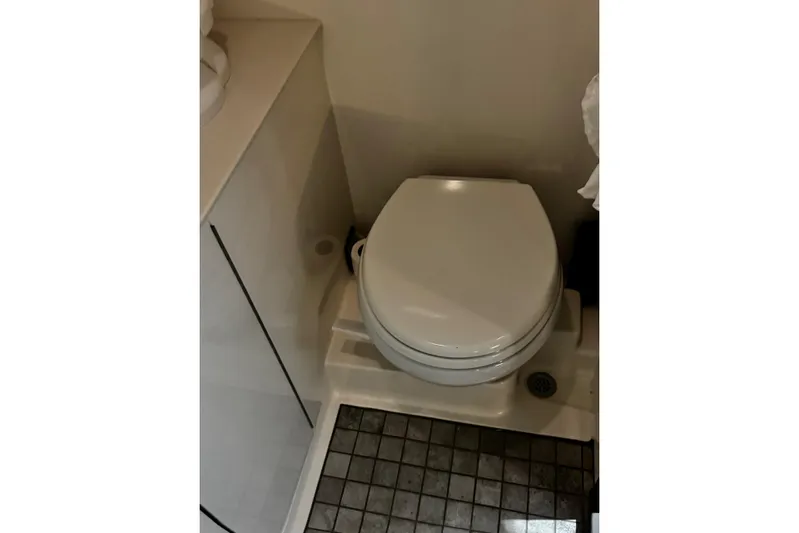  Yacht Photos Pics 2022 Sea Ray Sundancer 320 Outboard bathroom with compact toilet and tiled floor.