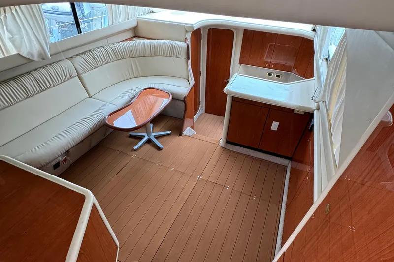  Yacht Photos Pics 2000 Sea Ray 380 Aft Cabin interior with curved seating and wooden table.