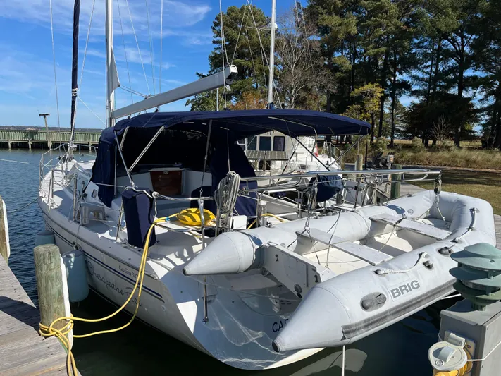 Chesapeake Free Yacht Photos Pics 2006 Catalina 387 sailboat docked with inflatable dinghy, surrounded by trees and clear sky.