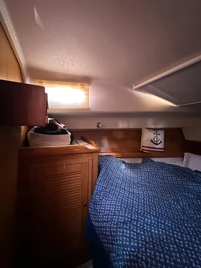 Chesapeake Free Yacht Photos Pics Cozy cabin interior of a 2006 Catalina 387 sailboat with blue bedding and wooden accents.
