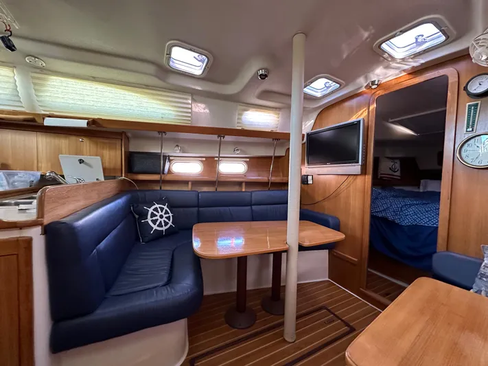 Chesapeake Free Yacht Photos Pics Interior of 2006 Catalina 387 sailboat with blue seating, wooden table, and cozy cabin.