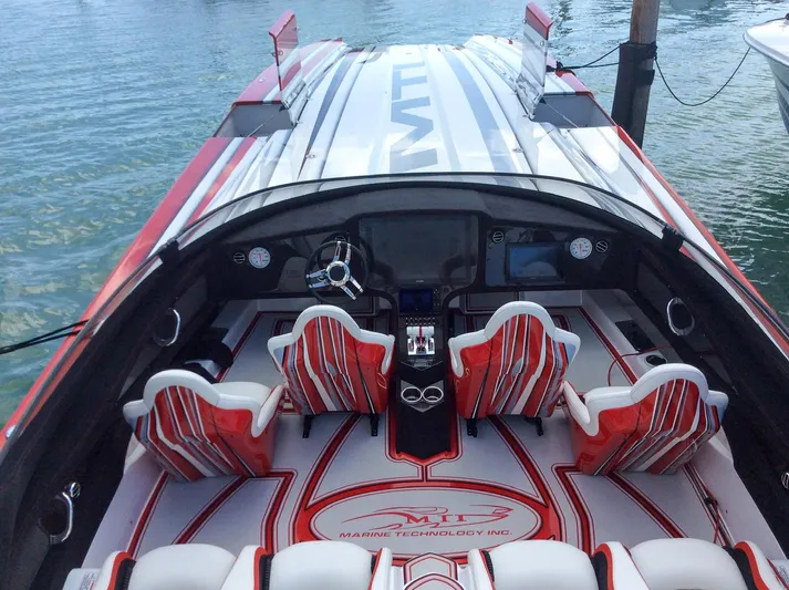  Yacht Photos Pics 2019 MTI 48 speedboat interior with red and white seating, sleek dashboard, and water backdrop.