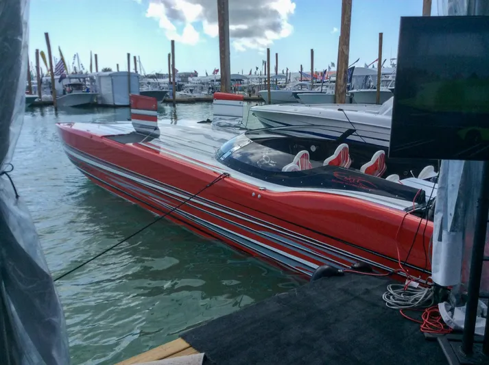  Yacht Photos Pics Red MTI 48 speedboat docked at marina, 2019 model, with sleek design and striped detailing.