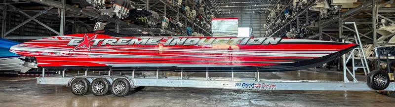  Yacht Photos Pics 2019 MTI 48 powerboat with "Extreme Induction" graphics on a trailer in a storage facility.
