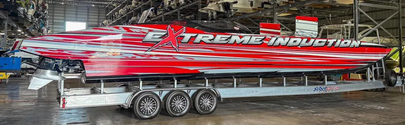  Yacht Photos Pics High-performance MTI 48 speedboat with vibrant red and white design in a warehouse setting.