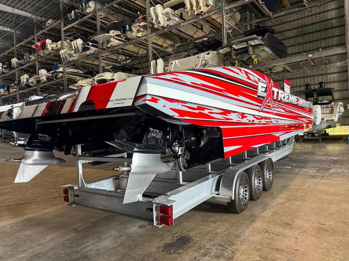  Yacht Photos Pics 2019 MTI 48 powerboat with red and white design on a trailer in a storage facility.
