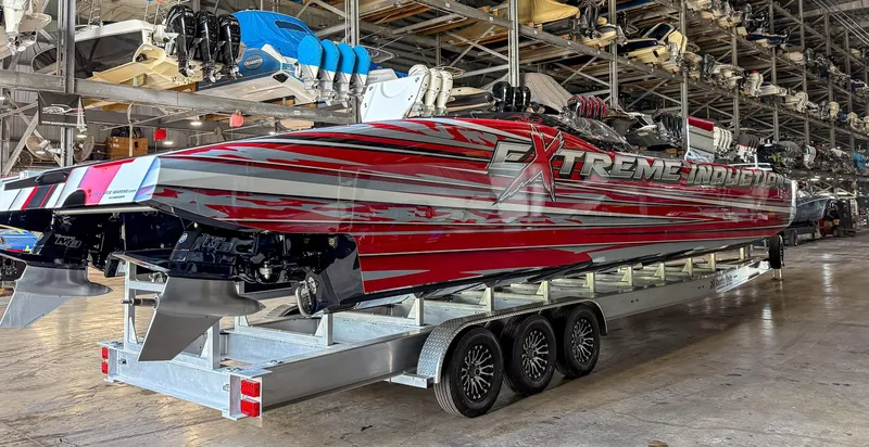  Yacht Photos Pics 2019 MTI 48 powerboat with vibrant red and silver design in a storage facility.