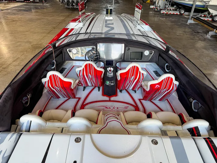  Yacht Photos Pics Luxurious 2019 MTI 48 speedboat interior with red and white seating, advanced dashboard controls.