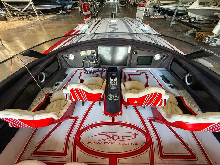  Yacht Photos Pics Interior of 2019 MTI 48 boat with red and white seating and advanced dashboard controls.