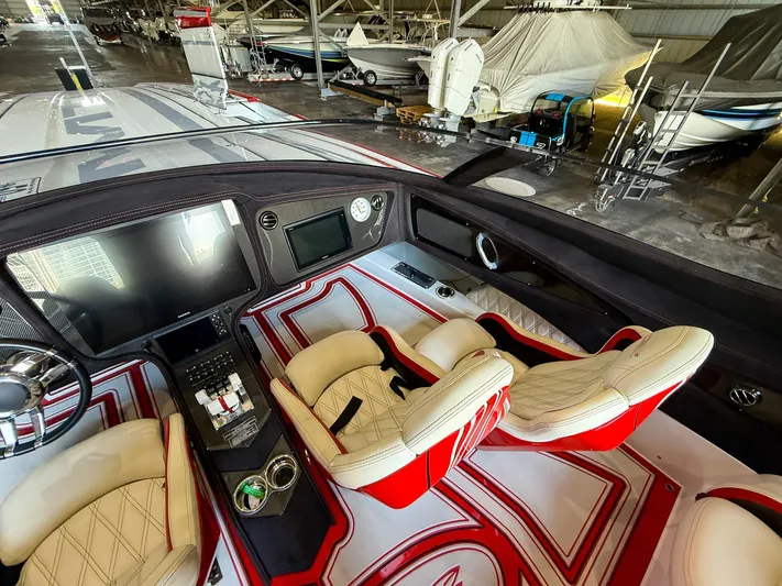  Yacht Photos Pics Luxurious MTI 48 boat interior with red and white seating, advanced dashboard, and steering wheel.