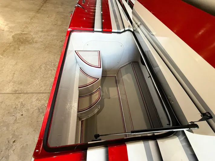  Yacht Photos Pics Open storage compartment in a 2019 MTI 48 boat with red and white design.