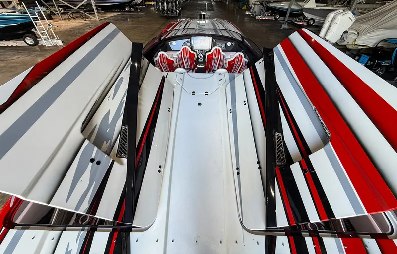  Yacht Photos Pics 2019 MTI 48 boat with sleek red, white, and black design in a storage facility.