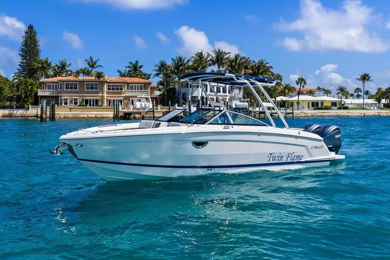 Twin Flame Yacht Photos Pics 2022 Cobalt R8 Outboard boat on clear blue water near luxury waterfront homes.