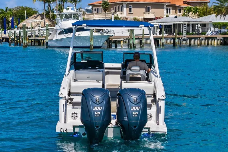Twin Flame Yacht Photos Pics 2022 Cobalt R8 Outboard boat cruising on clear blue water near a dock.
