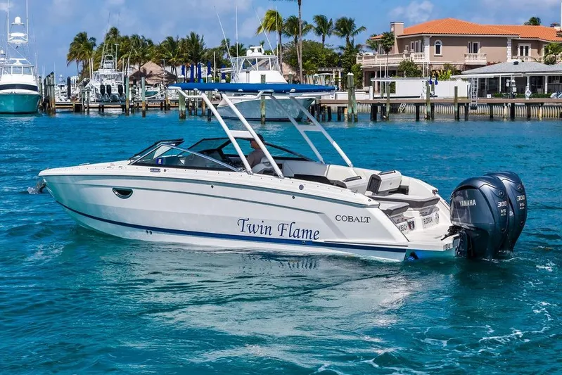 Twin Flame Yacht Photos Pics 2022 Cobalt R8 Outboard boat on clear blue water near a marina.
