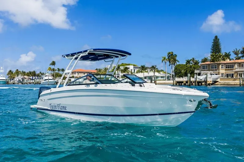 Twin Flame Yacht Photos Pics 2022 Cobalt R8 Outboard boat cruising on clear blue water near a tropical shoreline.