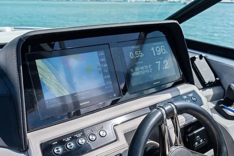 Twin Flame Yacht Photos Pics 2022 Cobalt R8 Outboard dashboard with Garmin navigation screens on a sunny day.