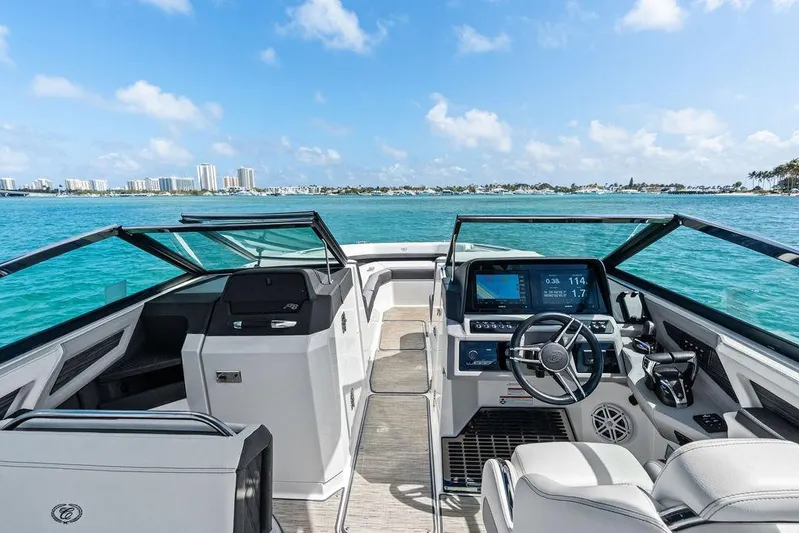 Twin Flame Yacht Photos Pics 2022 Cobalt R8 Outboard boat interior with modern dashboard, cruising on clear blue waters.