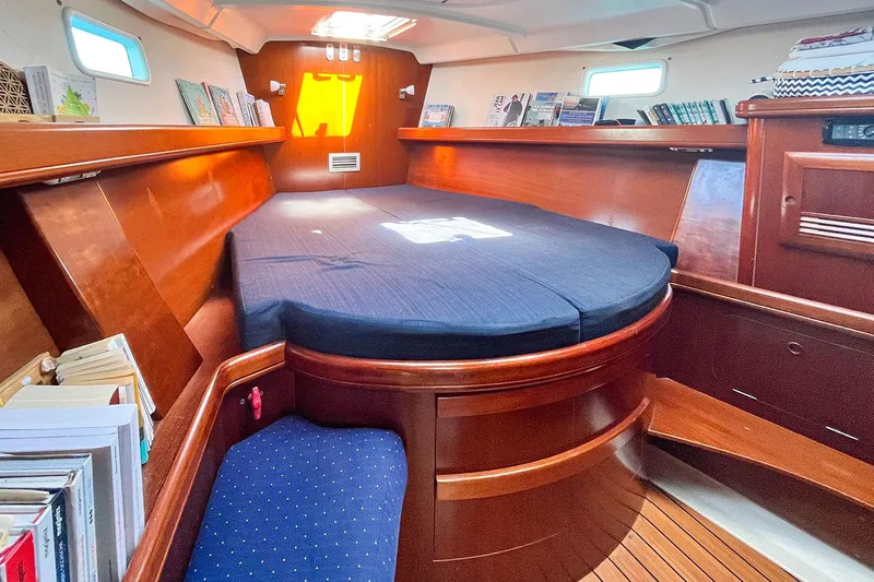  Yacht Photos Pics Interior cabin of 2002 Beneteau Oceanis Clipper 473 with wooden finish and cozy bedding.