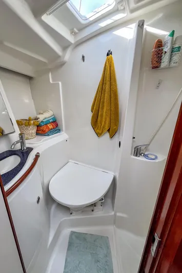  Yacht Photos Pics 2002 Beneteau Oceanis Clipper 473 bathroom with shower, sink, and storage shelves.