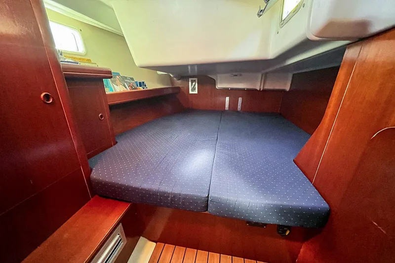  Yacht Photos Pics Interior cabin of 2002 Beneteau Oceanis Clipper 473 with wooden finish and blue bedding.