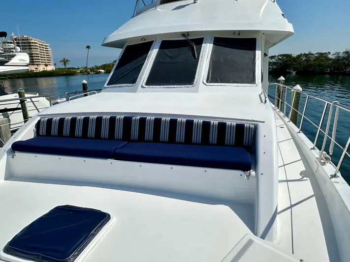 Leslie Jane Yacht Photos Pics 2002 Jefferson Marquessa 57 MY yacht with striped seating, docked by calm waters.