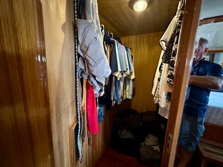 Leslie Jane Yacht Photos Pics Walk-in closet on 2002 Jefferson Marquessa 57 MY yacht with hanging clothes and wooden interior.