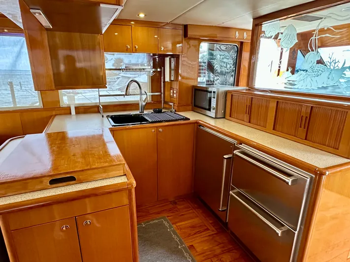 Leslie Jane Yacht Photos Pics Luxurious kitchen interior of 2002 Jefferson Marquessa 57 MY yacht with wood cabinetry and modern appliances.