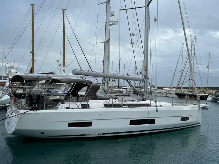  Yacht Photos Pics 2022 Dufour 470 sailboat docked in marina, overcast sky, sleek design.