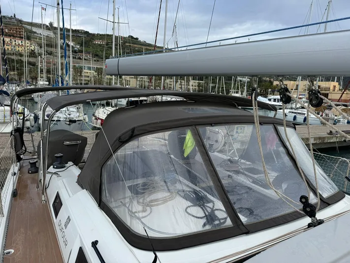  Yacht Photos Pics 2022 Dufour 470 sailboat with canopy, docked in a marina, surrounded by other boats.