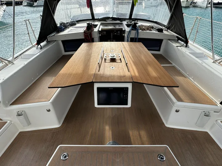  Yacht Photos Pics 2022 Dufour 470 yacht cockpit with wooden table and seating, docked at marina.