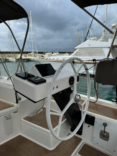  Yacht Photos Pics Steering wheel of 2022 Dufour 470 yacht, docked at marina under cloudy skies.